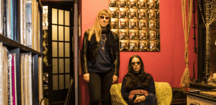Marcia Bassett stands next to Samara Lubelski in a room full of vinyl records